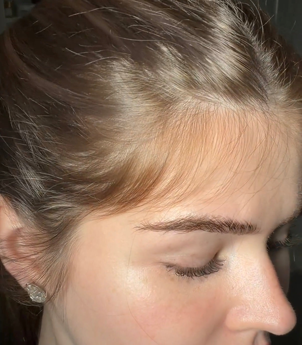 Close-up of a person's head with hair partially covering the face