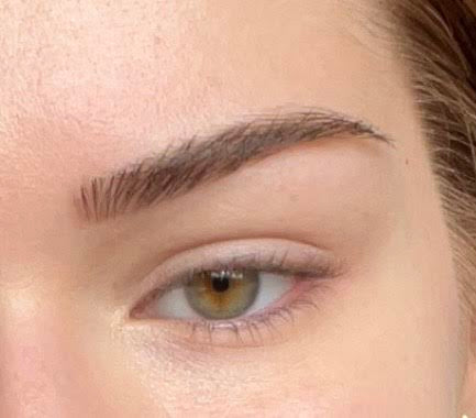 Close-up of a person's eye with a focus on the eyebrow.